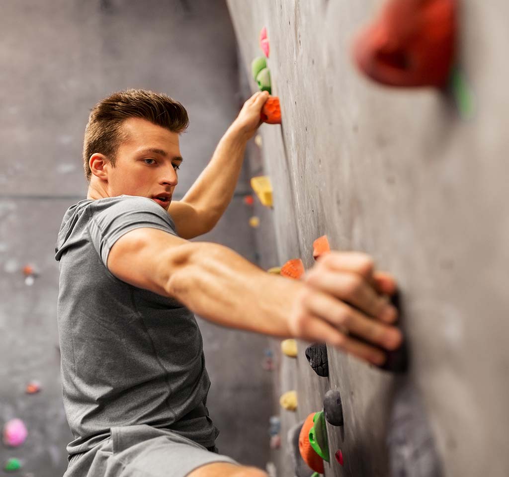 Teenager on in door rock climbing gym.