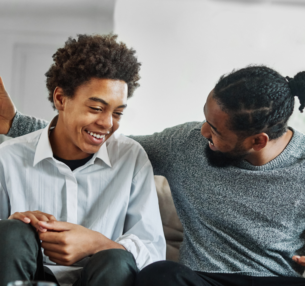 Father and Son laugh and chat together at home.